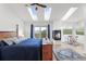 Tranquil bedroom with skylights, fireplace, balcony access, and views of the surrounding mountain landscape at 18844 Ute Vista Trl, Morrison, CO 80465