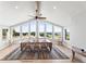 Dining room with large windows offering expansive views, a wooden table with seating for eight, and a ceiling fan at 18844 Ute Vista Trl, Morrison, CO 80465