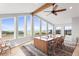 Bright dining room with a long wooden table, seating for eight, beamed ceiling, and views of the landscape at 18844 Ute Vista Trl, Morrison, CO 80465