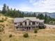 Beautiful home with a metal roof, large windows, and multiple decks surrounded by mature trees at 18844 Ute Vista Trl, Morrison, CO 80465