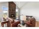 Cozy living room with a stone fireplace, hardwood floors, and views of the surrounding mountains at 18844 Ute Vista Trl, Morrison, CO 80465