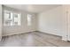 Minimalist bedroom with hardwood floors and ample natural light from two windows at 14109 Deertrack Ln, Parker, CO 80134