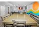 Cozy dining area featuring a large wooden table, TV, and unique wall mural, perfect for gatherings at 951 S Fulton St, Aurora, CO 80247