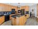 Modern kitchen with stainless steel appliances, wood cabinets, and a large island at 951 S Fulton St, Aurora, CO 80247