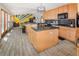 Open kitchen with island, wood cabinets, and gray tile floors extending to living area at 951 S Fulton St, Aurora, CO 80247