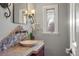 Powder room with granite vanity, vessel sink, and decorative stone backsplash at 3126 S Vine St, Englewood, CO 80113