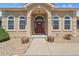 Inviting front door with an arched entryway, decorative windows, and security system at 38087 E 147Th Pl, Keenesburg, CO 80643