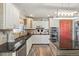 Bright kitchen with white cabinets, black countertops, stainless steel appliances and a charming island at 38087 E 147Th Pl, Keenesburg, CO 80643