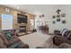 Spacious living room with wood panel wall, fireplace, and lots of natural light at 38087 E 147Th Pl, Keenesburg, CO 80643