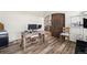 A cozy office space featuring wood floors, a modern desk setup, and a glimpse into the home's interior design at 38087 E 147Th Pl, Keenesburg, CO 80643