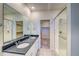 Bright bathroom featuring double sinks, granite countertops, tiled floors, and glass-enclosed shower at 23951 E 40Th Ave, Aurora, CO 80019