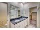 Bright bathroom featuring double sinks, granite countertops, tiled floors, and glass-enclosed shower at 23951 E 40Th Ave, Aurora, CO 80019