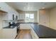 Bright kitchen with white cabinets, black countertops, and stainless steel appliances at 23951 E 40Th Ave, Aurora, CO 80019
