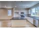 Open kitchen with island, white cabinets, stainless steel appliances, and bright natural light at 23951 E 40Th Ave, Aurora, CO 80019