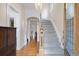 Bright foyer with hardwood floors, a grand staircase, decorative chandelier, and arched doorway creating an elegant entry at 564 S Grant St, Denver, CO 80209