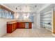 Basement kitchenette with wood cabinets and glass shelving at 14121 Countryhills Dr, Brighton, CO 80601