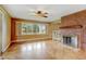 Living room with hardwood floors, brick fireplace, and large windows at 14121 Countryhills Dr, Brighton, CO 80601