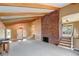 Open living room with vaulted ceilings, brick fireplace, and hardwood floors at 14121 Countryhills Dr, Brighton, CO 80601