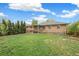 Lush backyard with green grass, mature trees, and a covered patio area, perfect for relaxation and outdoor activities at 3620 Fairfax St, Denver, CO 80207
