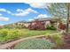 Brick home featuring a landscaped front yard with mature trees and a walkway to the covered porch at 3620 Fairfax St, Denver, CO 80207