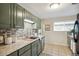 Modern kitchen features sage green cabinets, mosaic backsplash, and stainless dishwasher at 3620 Fairfax St, Denver, CO 80207