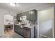Updated kitchen displays green cabinets, stainless dishwasher, and view into dining area at 3620 Fairfax St, Denver, CO 80207