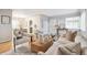 Bright, open-concept living room with hardwood floors, stylish decor, and a view into the dining area at 3620 Fairfax St, Denver, CO 80207