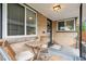 Cozy front porch with seating, brick walls, and a secure screen door entrance at 3620 Fairfax St, Denver, CO 80207