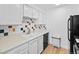 Updated kitchen features white cabinets, neutral countertops, and colorful backsplash at 14206 E 1St Dr # B10, Aurora, CO 80011