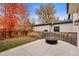 Backyard featuring a stone patio, modern fire pit, and mature trees at 2218 S Clayton St, Denver, CO 80210