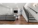 Finished basement with a staircase, gray sofa and flatscreen television above a media cabinet at 2218 S Clayton St, Denver, CO 80210
