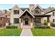 Stunning two-story home boasts a brick facade, covered porch, black trim windows, and beautiful landscaping at 2218 S Clayton St, Denver, CO 80210