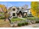 Charming two-story home with a brick facade, black trim windows, manicured lawn, and wrought iron fence at 2218 S Clayton St, Denver, CO 80210