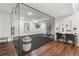 Basement gym featuring glass enclosure, black floor, workout space, and desk area at 2218 S Clayton St, Denver, CO 80210