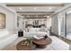 Bright living room featuring hardwood floors, beamed ceilings, and a seamless flow to the kitchen at 2218 S Clayton St, Denver, CO 80210
