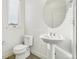 Modern powder bathroom features a pedestal sink, toilet and window for natural light at 5668 Galena St, Denver, CO 80238