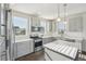 Bright kitchen features stainless steel appliances, gray cabinets and quartz countertops at 5668 Galena St, Denver, CO 80238