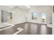 Bright, open living room with large windows and dark hardwood floors at 5668 Galena St, Denver, CO 80238