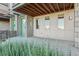 Outdoor patio with a view of manicured greenery, a green door, and warm lighting at 5668 Galena St, Denver, CO 80238