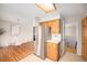 Kitchen area with stainless steel refrigerator, wooden cabinets, and a view of the dining area at 1529 Ashcroft Dr, Longmont, CO 80501
