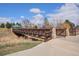 A brown walking bridge in a community park, lined by stone pillars and greenery at 1529 Ashcroft Dr, Longmont, CO 80501