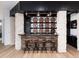 Stylish bar area with unique wooden barrel decor, and stone accent columns for an entertaining space at 860 Diamond Ridge Cir, Castle Rock, CO 80108