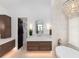 Elegant bathroom featuring dual vanity, a standalone soaking tub, and walk-in closet access at 860 Diamond Ridge Cir, Castle Rock, CO 80108