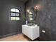 Stylish powder room with marble floating vanity, dark accent wall, and bronze fixtures at 860 Diamond Ridge Cir, Castle Rock, CO 80108