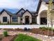 Close-up of the home's facade, showcasing its stone accents, arched doorway, and meticulously landscaped garden at 860 Diamond Ridge Cir, Castle Rock, CO 80108