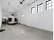 Spacious garage featuring epoxy floors, white walls and multiple windows for natural light at 860 Diamond Ridge Cir, Castle Rock, CO 80108