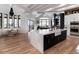 Bright, open-concept kitchen features an island with marble countertop, farmhouse sink, and modern black and white cabinetry at 860 Diamond Ridge Cir, Castle Rock, CO 80108