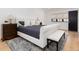 Bright main bedroom featuring a tufted headboard, a bench and a neutral color palette with a door to the ensuite at 860 Diamond Ridge Cir, Castle Rock, CO 80108