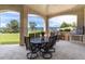 Covered outdoor patio with stone arches, dining set, built-in grill, and scenic views at 860 Diamond Ridge Cir, Castle Rock, CO 80108