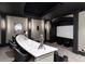 Home theater displaying plush seating and sleek design with a tray ceiling and a projector screen at 860 Diamond Ridge Cir, Castle Rock, CO 80108
